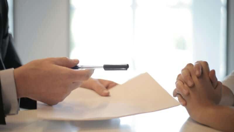 June 25th, 2025 : The AI Industry's Biggest Plot Twist: How Strategic Partnerships Are Reshaping Competition 1 Close-up of a contract signing with hands over documents. Professional business interaction.